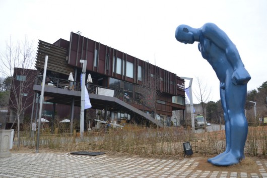 Blue man statue with Chocolate Design Factory in background