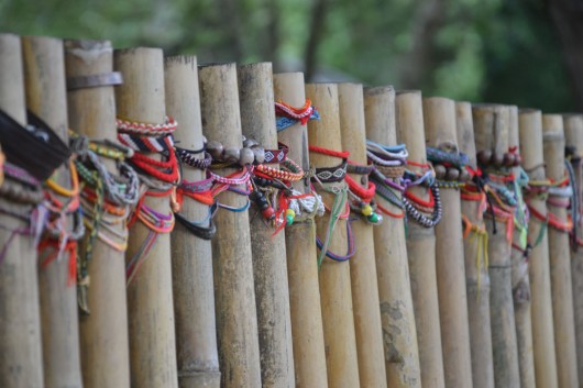 Friendship and peace bracelets are hung around the mass graves